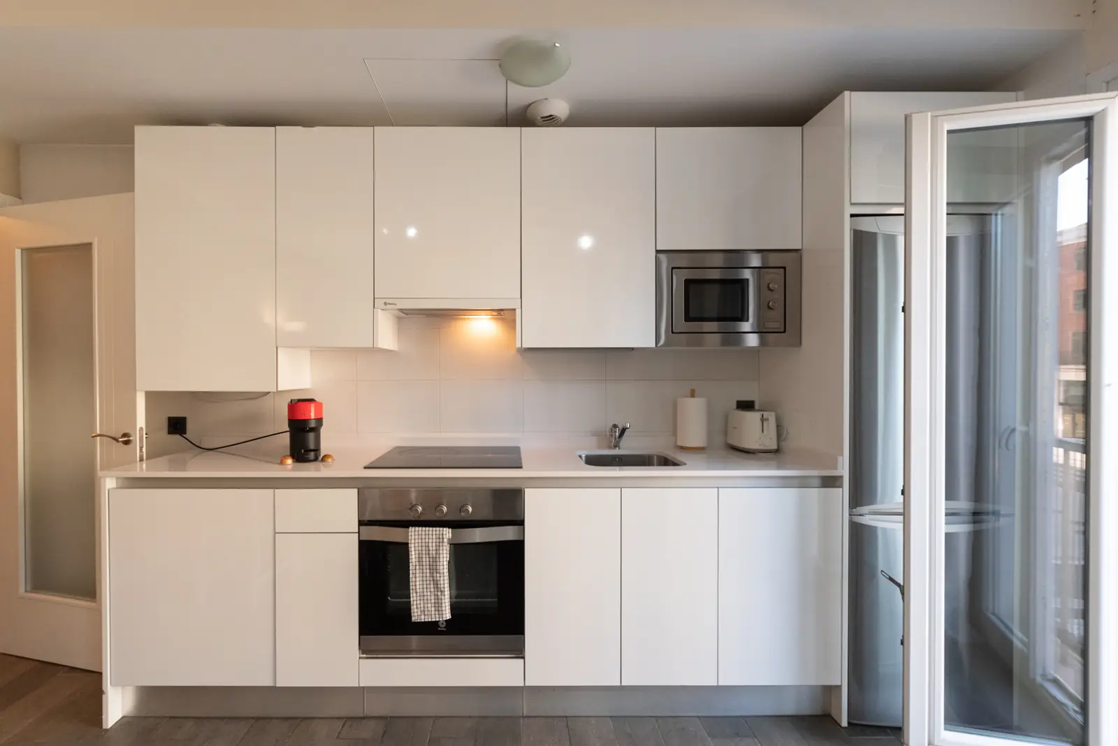 The white kitchen, with ceramic hob, oven, microwave and coffee machine