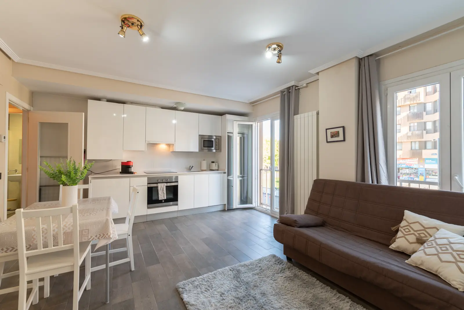 The living room, with the sofa bed and the large window onto the street